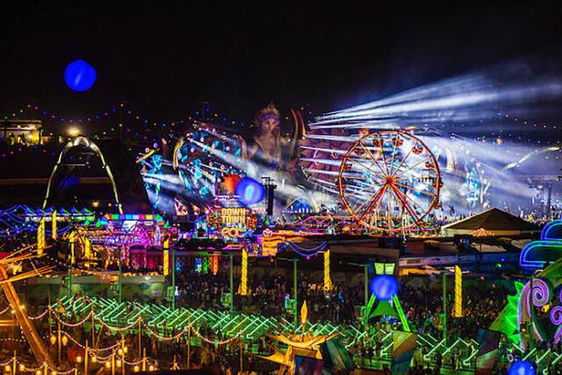 Das Electric Daisy Carnival (EDC) Festival in Las Vegas bei Nacht mit Riesenrad und Menschenmassen.