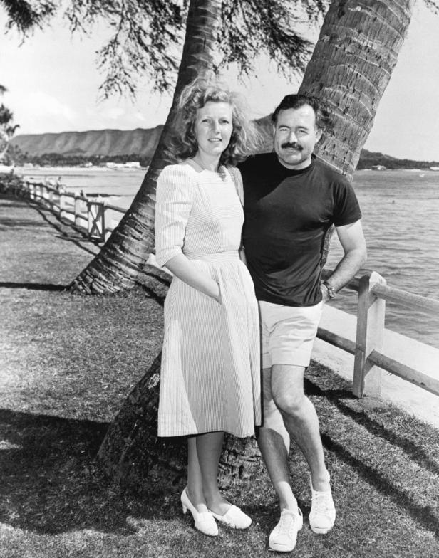 Ernest Hemingway und seine Frau Mary Welsh stehen an einem Baum am Strand.
