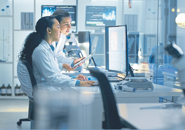 Zwei Wissenschaftlerinnen arbeiten in einem Labor an einem Computer.