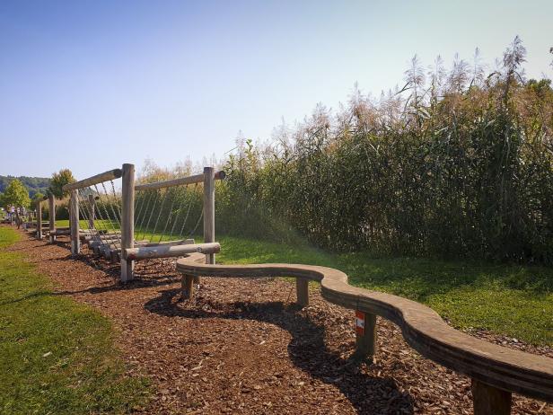 Ein Hindernisparcours aus Holz auf einem Spielplatz im Grünen.