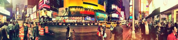 Der Times Square in New York ist voller Menschen und heller Werbetafeln.