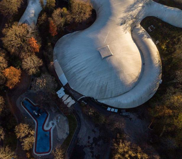 Luftaufnahme der Multihalle Mannheim, umgeben von Bäumen.
