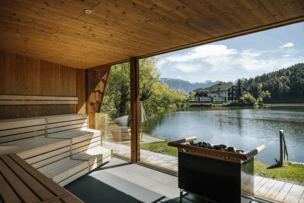 Eine Sauna mit Blick auf einen See und die Berge.