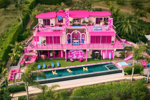 Ein großes, pinkfarbenes Barbie-Haus mit Pool und dem Schriftzug „KEN“.