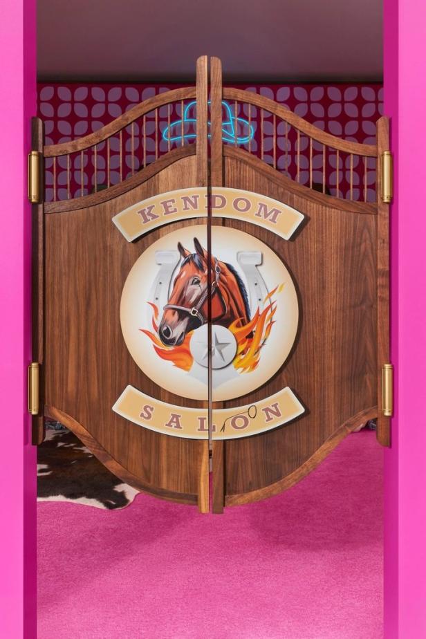 Die Saloontüren des „Kendom Saloon“ mit einem Pferdebild und Neon-Cowboyhut.