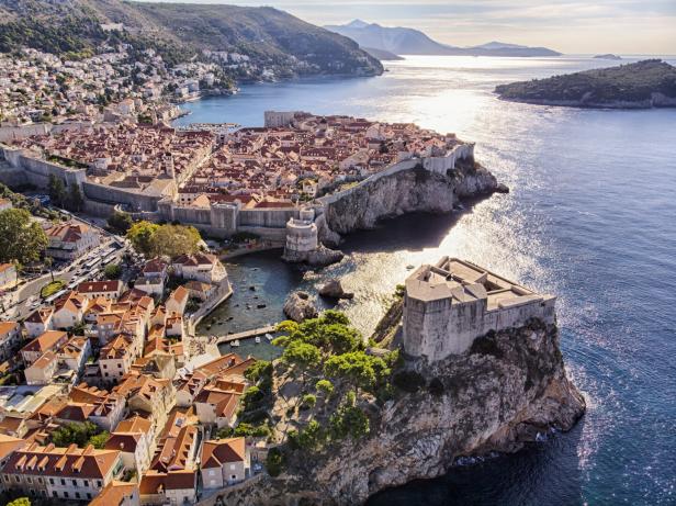 Die Altstadt von Dubrovnik, umgeben von einer steinernen Stadtmauer, liegt an der Küste.