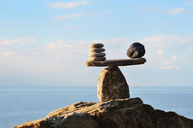 Ein Steinturm balanciert auf einem Felsen am Meer.