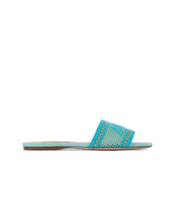 Ein türkisfarbener Damenslipper mit einem durchbrochenen Muster auf weißem Hintergrund.