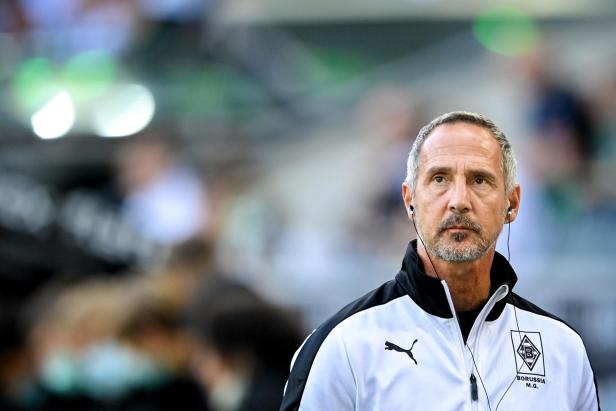 Ein Mann mit Kopfhörern und einer Jacke von Borussia Mönchengladbach.