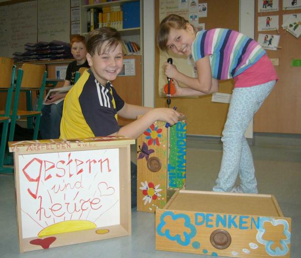 Schüler präsentieren und bearbeiten Werkstücke mit Aufschriften wie „gestern und heute“ und „miteinander denken“.