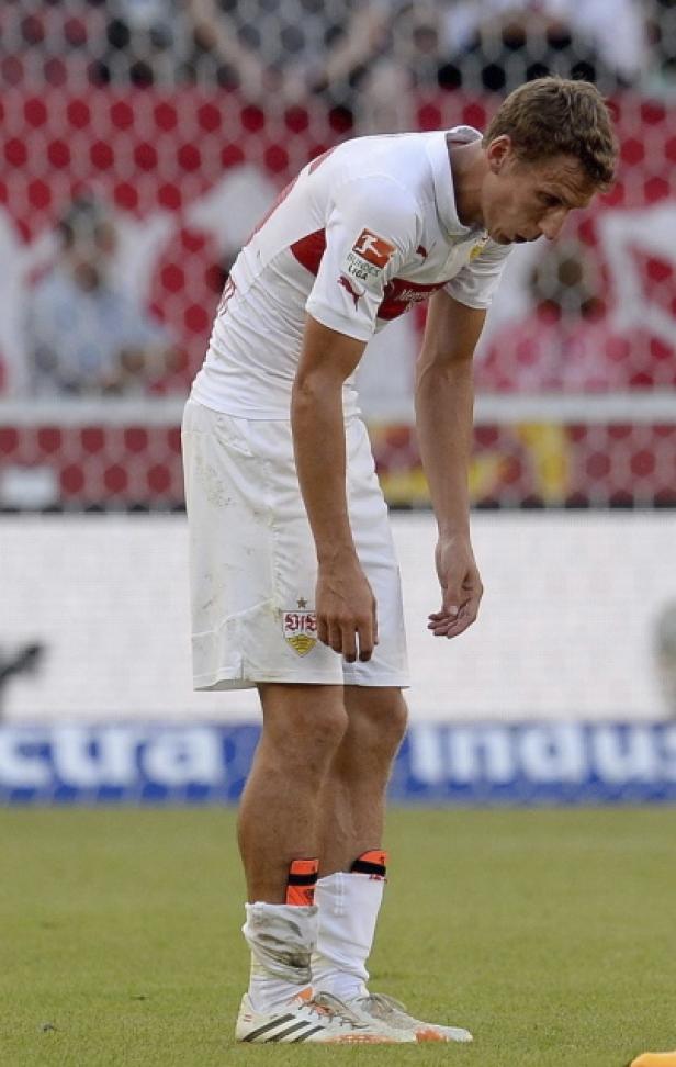 Ein Fußballspieler des VfB Stuttgart steht mit gesenktem Kopf auf dem Rasen.