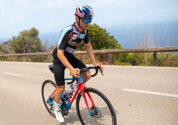 Ein Radfahrer fährt auf einer Küstenstraße mit Blick auf das Meer.