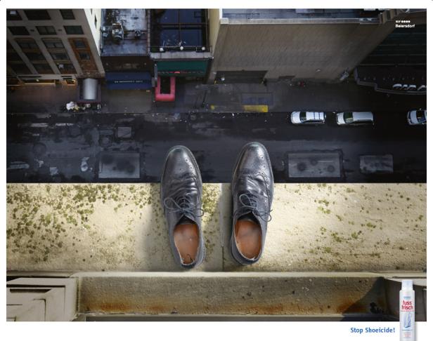 Zwei Schuhe stehen auf einem Dach mit Blick auf eine Straßenschlucht.