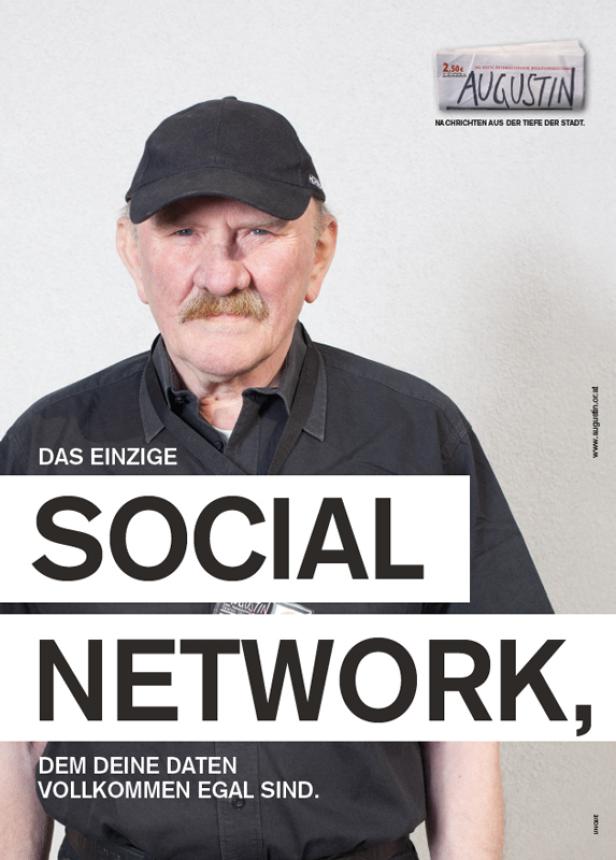 Ein älterer Mann mit Schnurrbart und Kappe vor einer Werbung für die Zeitschrift „Augustin“.