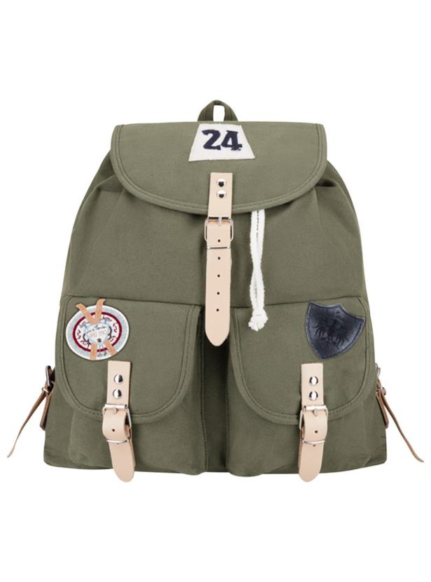 Ein olivgrüner Rucksack mit hellbraunen Lederriemen und verschiedenen Aufnähern.