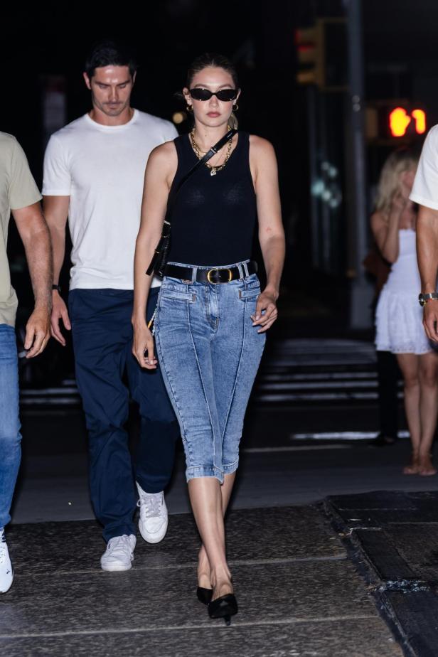 Gigi Hadid mit Sonnenbrille, Tanktop und Jeans auf der Straße.