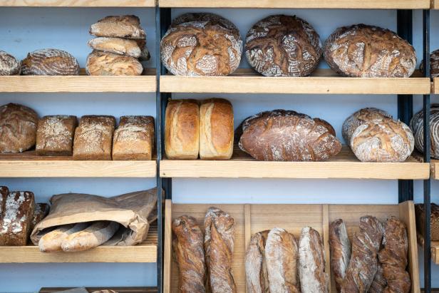 Regale in einer Bäckerei sind mit verschiedenen Brotsorten gefüllt.