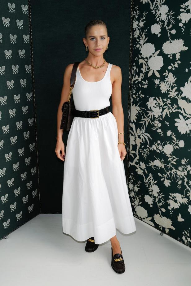 Eine Frau in einem weißen Kleid posiert bei der Polo Ralph Lauren Veranstaltung in Wimbledon 2023.
