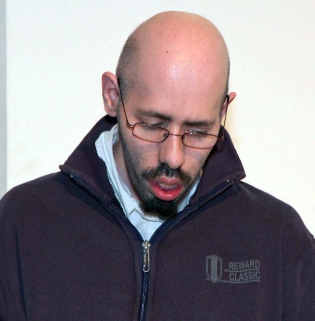 Ein Mann mit Brille und Bart schaut nach unten.