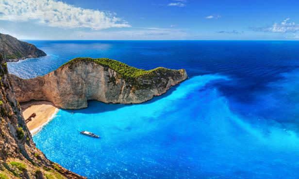 Blick auf die Navagio-Bucht mit einem Schiff und einem Schiffswrack am Strand.