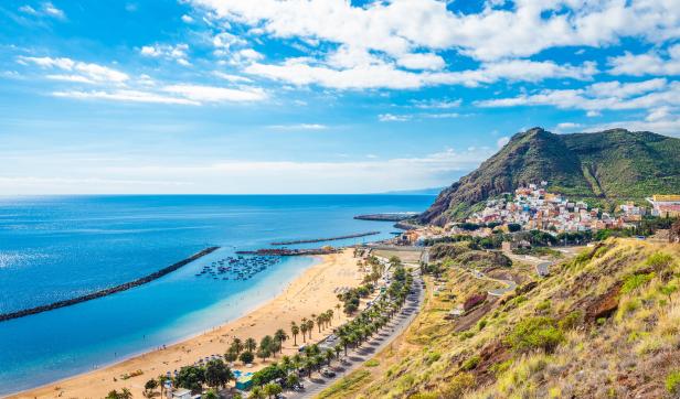 Ein Panoramablick auf den Strand Las Teresitas auf Teneriffa mit einem Berg im Hintergrund.