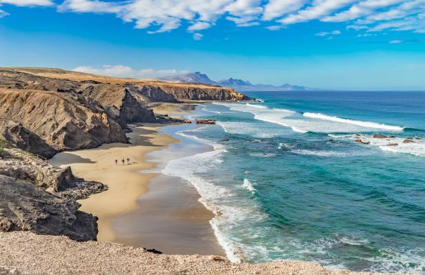 Blick auf die Küste von Fuerteventura mit Klippen, Strand und türkisfarbenem Wasser.