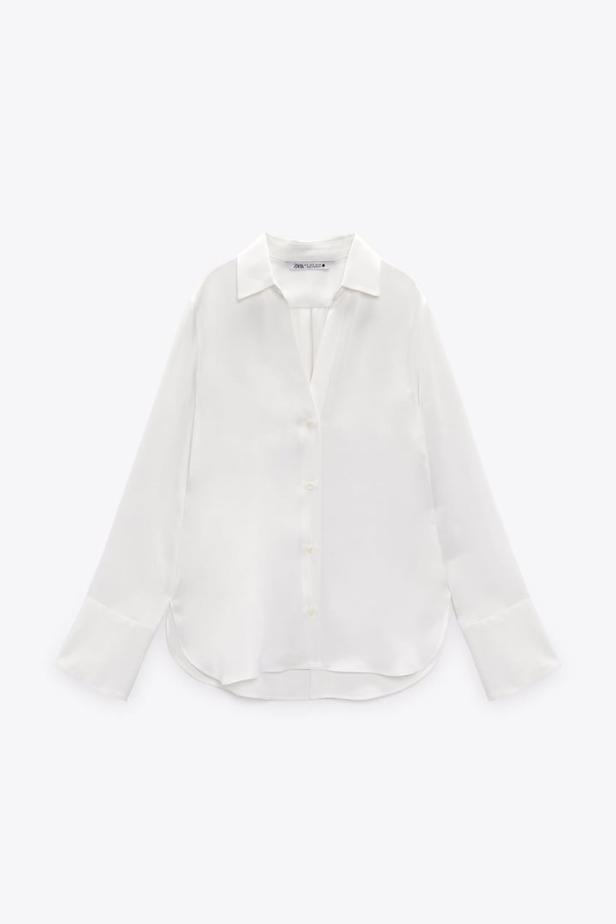 Eine weiße, langärmlige Bluse mit Kragen und Knöpfen.