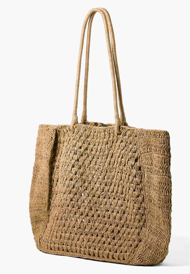 Eine große, gehäkelte Handtasche aus Bast mit langen Henkeln.