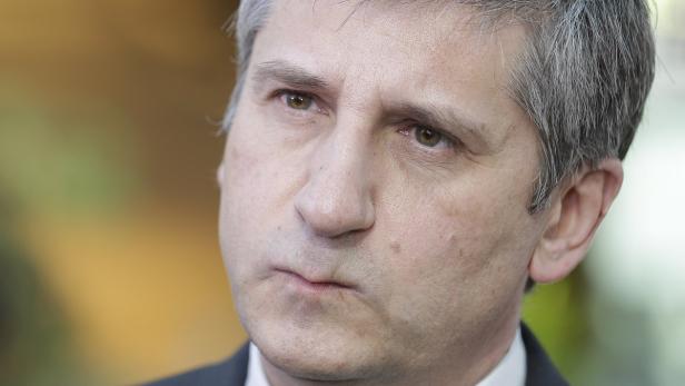 Nahaufnahme eines Mannes mit grau meliertem Haar und ernstem Gesichtsausdruck.