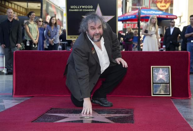 Peter Jackson kniet auf dem Hollywood Walk of Fame neben seinem Stern.