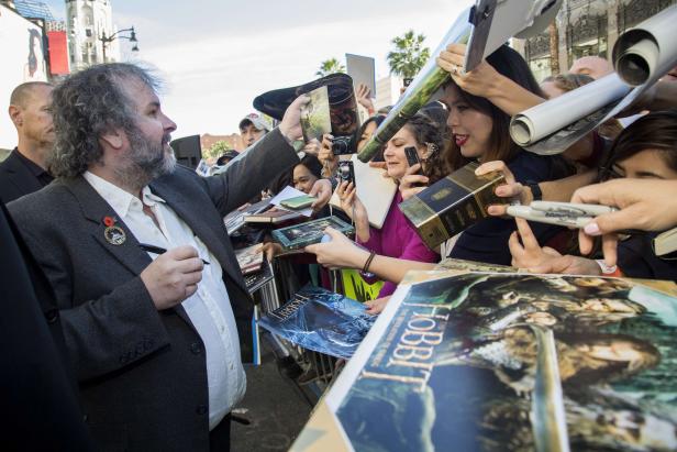 Peter Jackson gibt Autogramme auf Bücher und Poster von „Der Hobbit“ und „Der Herr der Ringe“.