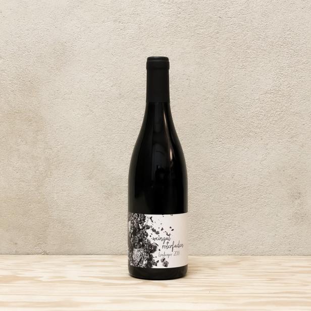 Eine Flasche „Weingut Roterfaden Lemberger 2018“ steht auf einem Holztisch.
