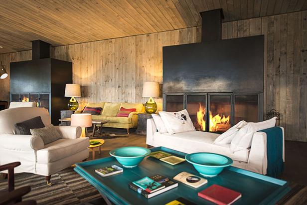 Ein Wohnzimmer mit Holzwänden, einem Kamin und hellen Möbeln.