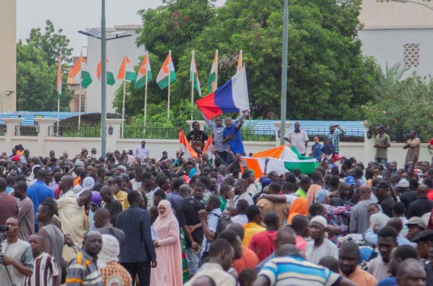 Hundreds of supporters of the coup gather and hold a Russian flag in Niamey