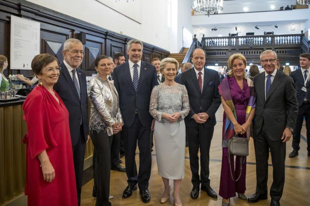 Eine Gruppe von Politikern posiert für ein Foto in einem eleganten Saal.