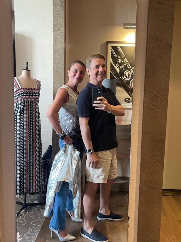 Ein Paar macht ein Selfie vor einem Spiegel, in dem ein Kleid zu sehen ist.