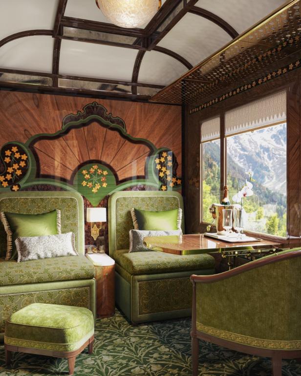 Innenansicht eines luxuriösen Abteils im Simplon Orient Express mit grünen Sitzen und Blick auf die Berge.