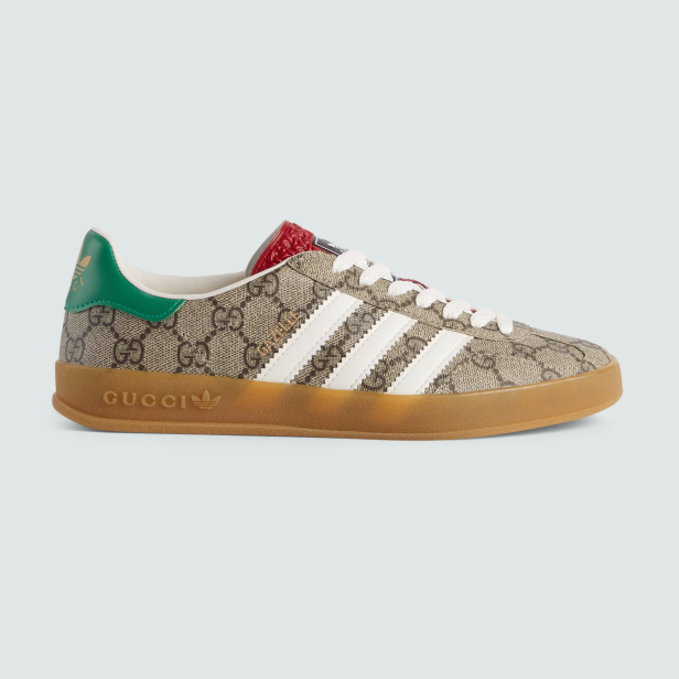 Ein Gucci x Adidas Gazelle Sneaker mit braunem Muster und weißen Streifen.