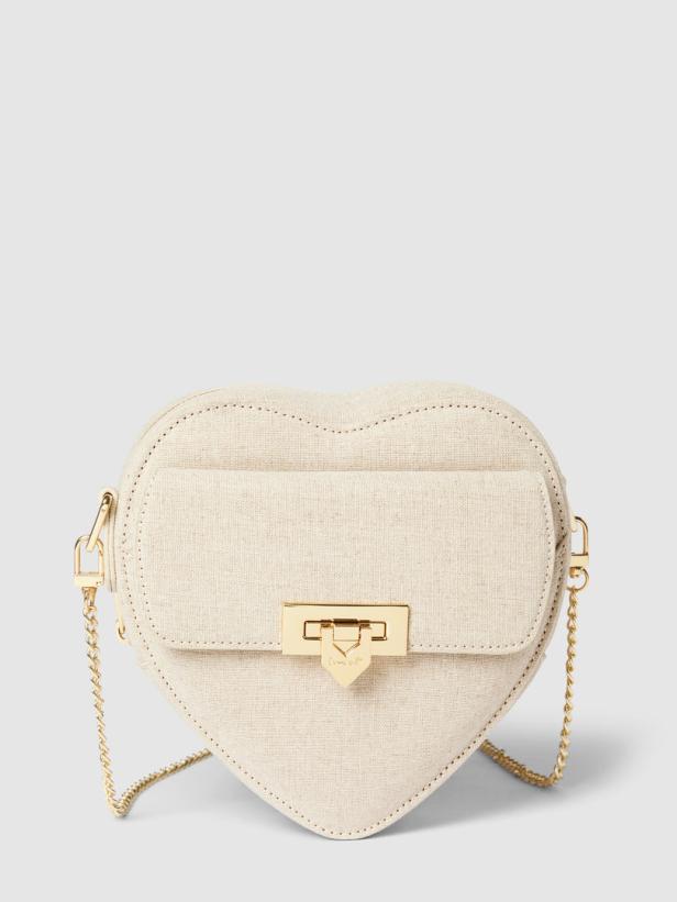 Eine herzförmige, beige Handtasche mit goldenen Details und einer Kette.