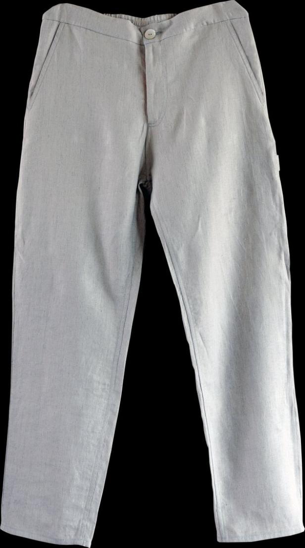 Eine hellgraue Stoffhose mit Knopf liegt vor einem schwarzen Hintergrund.