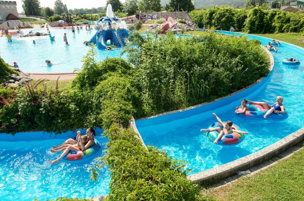 Menschen entspannen sich auf Schwimmreifen in einem Wasserparkkanal.