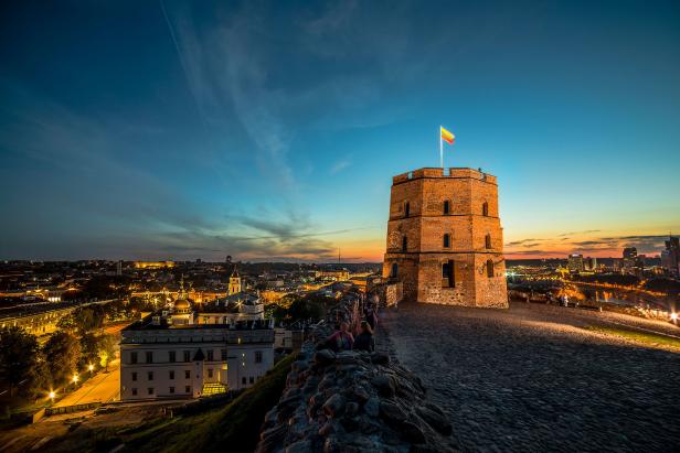 Der Gediminas-Turm in Vilnius mit der litauischen Flagge bei Dämmerung.