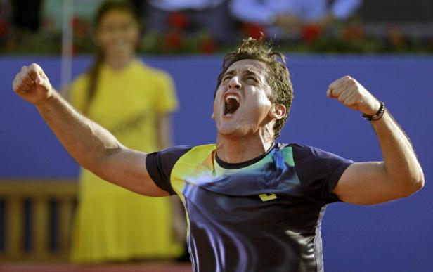 Ein Tennisspieler jubelt mit geballten Fäusten und geöffnetem Mund über seinen Sieg.