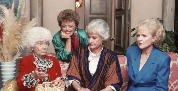 Die vier Hauptdarstellerinnen der Fernsehserie „Golden Girls“ sitzen auf einer Couch.