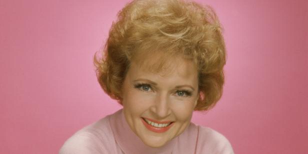 Ein Porträt von Betty White vor einem rosa Hintergrund.