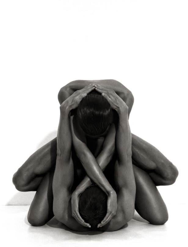 Zwei nackte Personen sitzen ineinander verschlungen auf dem Boden.