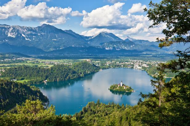 Der Bleder See mit der Insel und der Kirche Maria Himmelfahrt vor der Bergkulisse der Julischen Alpen.