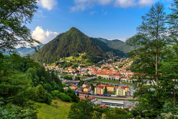 Ein Blick auf die Stadt Kamnik in Slowenien, eingebettet zwischen bewaldeten Hügeln.