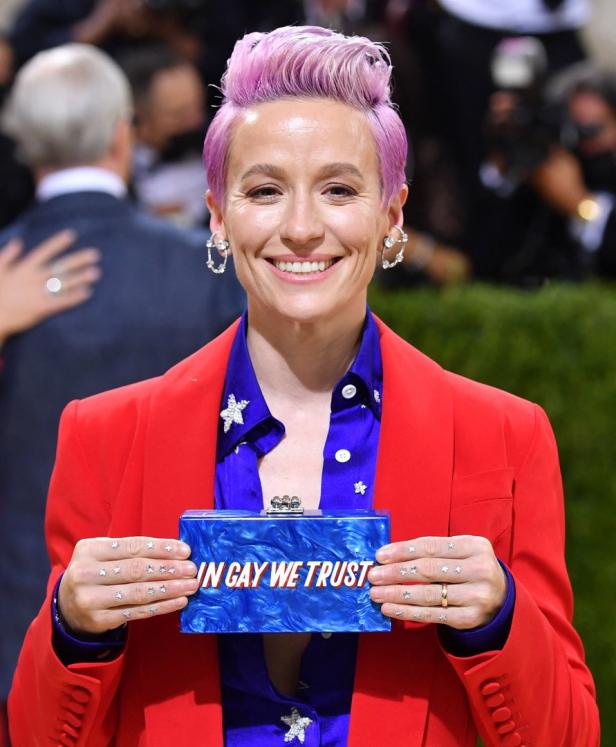 Megan Rapinoe hält eine Clutch mit der Aufschrift „In Gay We Trust“.