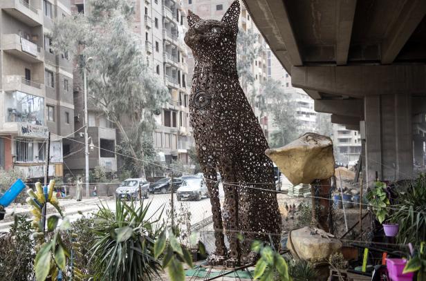 Eine große Skulptur einer Katze steht auf einer Straße in einer Stadt.